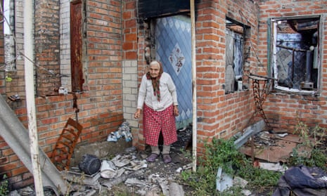 A woman at her destroyed house after Russian shelling in Korobochkyne village in Ukraine's Kharkiv region