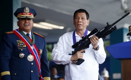 Rodrigo Duterte holds a rifle next to national police chief Ronald ‘Bato’ dela Rosa