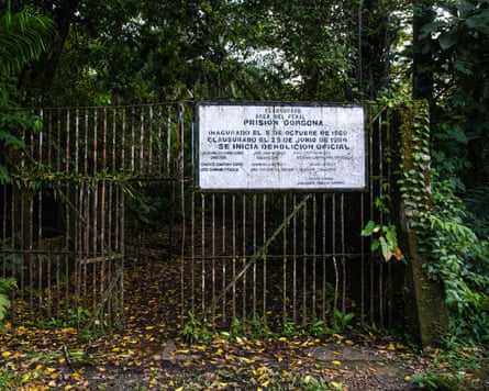 A sign in Spanish saying ‘Prisión Gorgona’ attached to a metal fence with a gate in it.