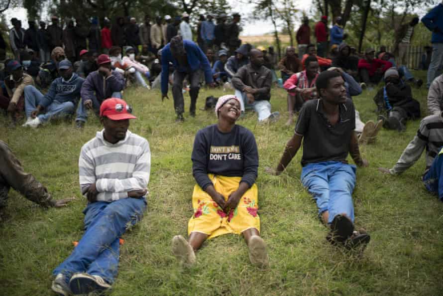 Homeless people wait for food parcels in a Johannesburg park