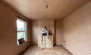 The plasterer is killing time before the ‘dry trowel’ (smooth ridges, bumps or excess plaster) to create the end finish to the walls and ceilings. Love those stilts.