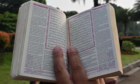 A demonstrator holds a copy of the Qur’an with accompanying translation during a rally in Jakarta