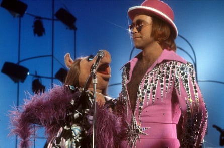 Miss Piggy in pink feather boa sings with Elton John in pink rhinestone suit and top hat