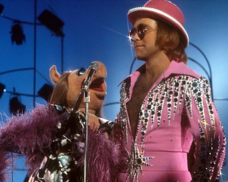 Elton John wears pink jumpsuit with rhinestones detailing while performs with Miss Piggy.