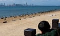A child looks towards China's Xiamen city from the coast in Kinmen with fortifications along the beach