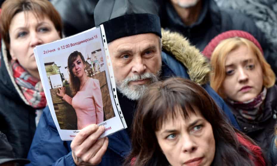 An Orthodox priest holds a picture of Iryna Nozdrovska during a protest outside Kiev police HQ against the murder of the Ukrainian lawyer who helped convict her sister’s well-connected killer.