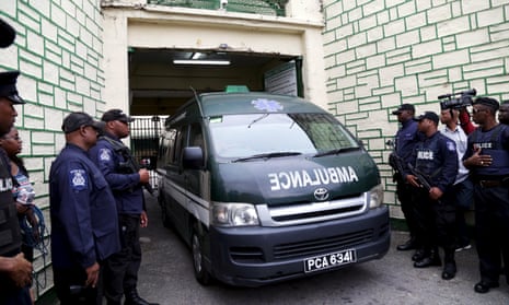 Police stand guard as an ambulance leaves the state prison in Port-of-Spain on Thursday. According to local media Jack Warner left jail in Trinidad and Tobago via ambulance