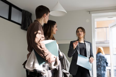 A couple being shown around a house by an estate agent