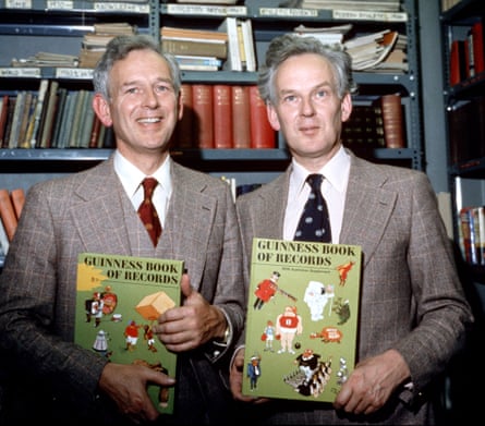 Norris and Ross McWhirter holding up Guinness World Records books in a library.