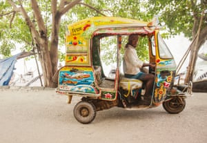 A small tuk painted in vivid blue and yellow colours