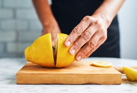 Citrus is also a good idea – juice, flesh and zest – great in dressings and salads. Hands of woman cutting lemons on cutting board.