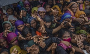Rohingya women, who fled from Myanmar, wait for aid to be distributed at a camp in Bangladesh.