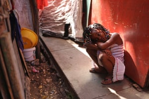 A young girl crouches on a low wall