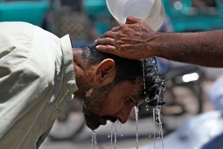 A volunteer pours water on a man’s head during a May 2024 heatwave in Karachi, Pakistan.