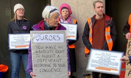 Trudi Warner holds a sign saying: ‘Jurors, you have an absolute right to acquit a defendant according to your conscience’. Other people stand behind her holding signs repeating the wording of the marble plaque celebrating the Bushel case