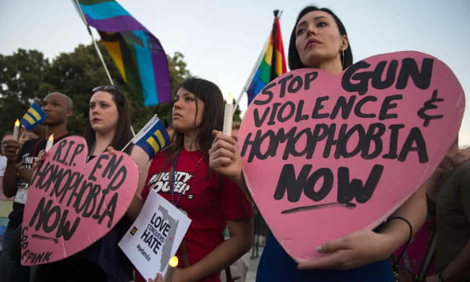 Mourners hold up signs during a vigil in Washington, in reaction to the mass shooting at a gay nightclub in Orlando, Florida.