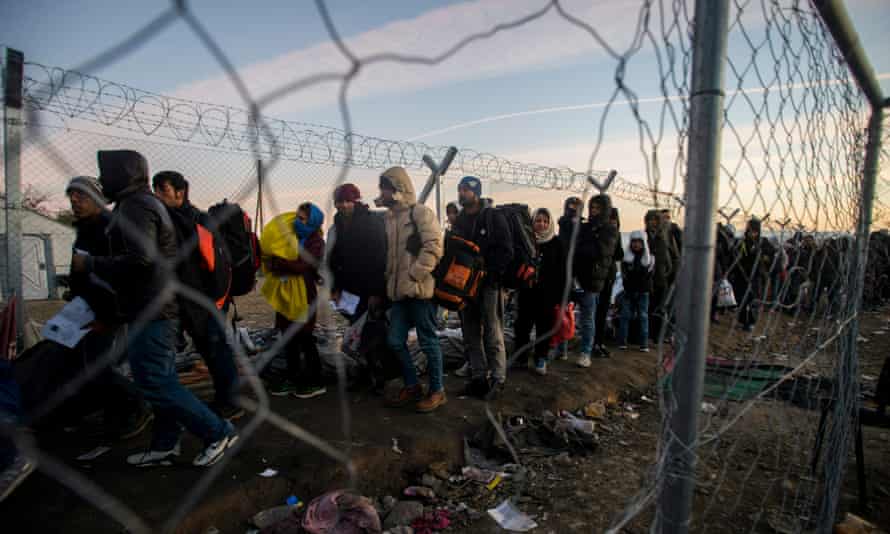 People wait in line to cross the border between Greece and Macedonia