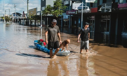 Guardian- Ballina CBD flood. River Street, main street of CBD. Evacuees walk out of West Ballina with their dog. 2nd March 2022 Photo by Natalie Grono Flooding across Ballina in Northern NSW, Australia. Most of the suburb had to be evacuated as flood waters covered the region. Australia, floods, storm, flooding.