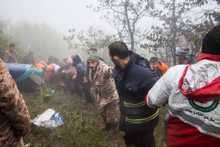 Rescue team members forming a human chain on a foggy slope