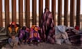 Asylum seekers bundle up against the cold after spending the night outside along the US-Mexico border fence in December 2022.