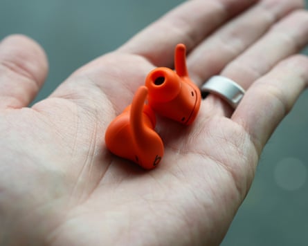 The Beats Powerbeats Fit earbuds in the palm of a hand.