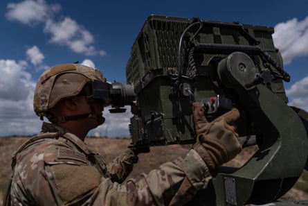 A soldier looks through a surveillance system viewfinder.