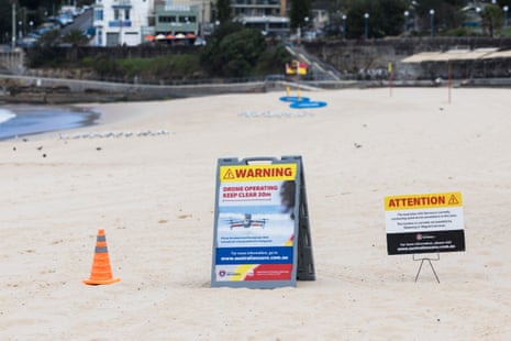 Signs on a sandy beach warning drones are in operation