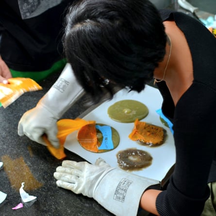 A woman wearing heavy-duty gloves at work in a plastic-upcycling workshop.