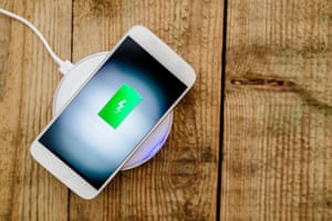 White smartphone charging on a charging pad. Wireless chargingJR41B5 White smartphone charging on a charging pad. Wireless charging