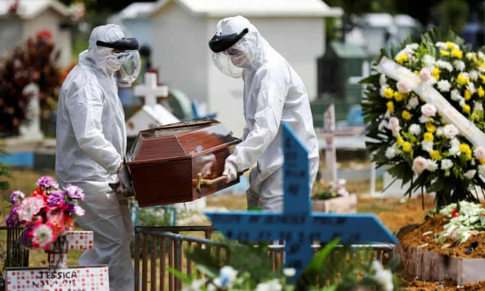 Gravediggers wearing protective suits carry the coffin of 68-year-old Natalina Cardoso Bandeira, who passed away due to coronavirus disease