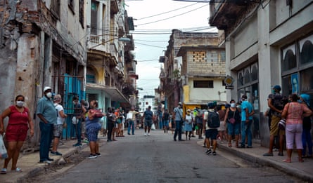 People queue to buy food in Havana.