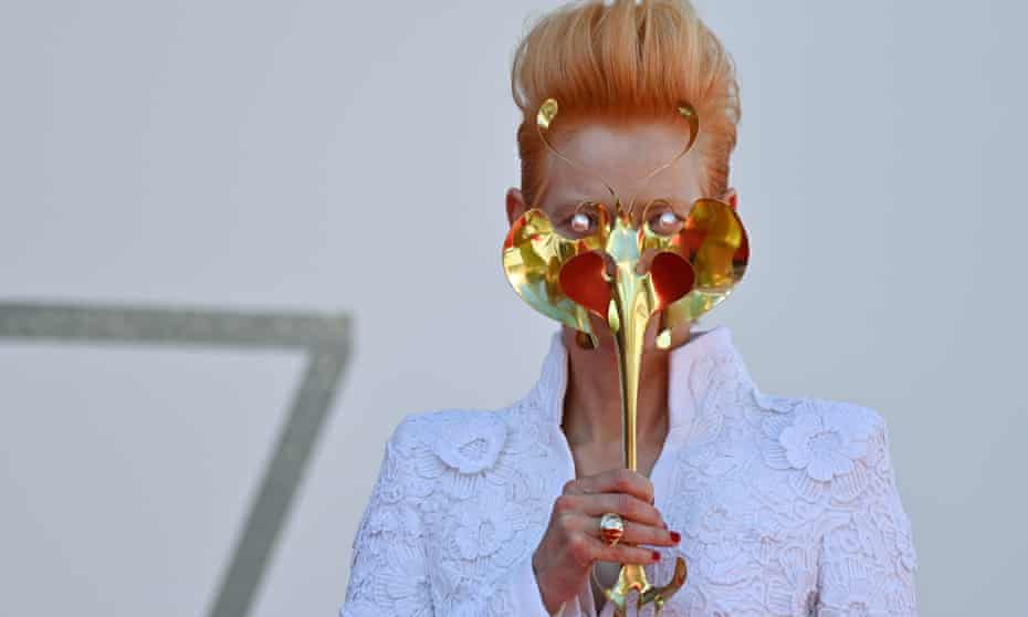 Tilda Swinton holds a golden masquerade mask as she arrives for the screening of the film The Human Voice at the Venice Film Festival last week.