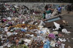 A woman dumps trash at the Oriental market in the capital city Managua, Nicaragua. The country has several confirmed cases of Zika