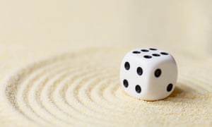 A dice landing on sand.