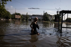 A pedestrian wades through rising flood water in central Kherson