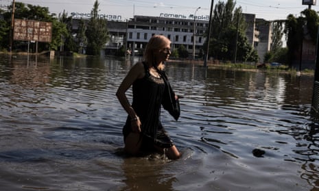 People wade through rising flood water in central Kherson.