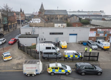 Police vans outside an industrial-looking building