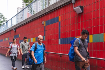 The Yip family (from left) – Lam Ka-Wan Karen, Yip Shun-Ting Carbon and father Yip Ka-kui and elder brother Yip Shun Yin – walk to the government-arranged coach pickup point to return to Wang Fuk Court and retrieve belongings from their fire-ravaged flat.