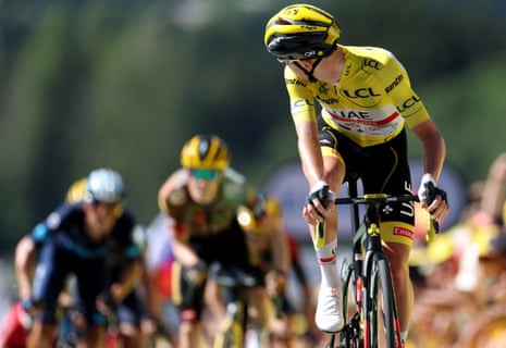 UAE Team Emirates team's Tadej Pogacar, wearing the overall leader's yellow jersey, looks back as he cycles to the finish line.