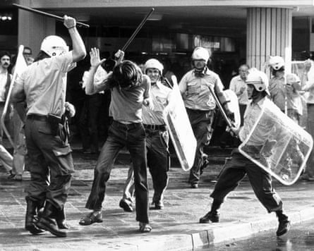 Black and white photo of policemen beating unarmed demonstrators with batons.