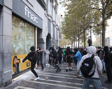 Demonstrators smash a shop window as protesters clash with riot police during a high school students' demonstration against education spending cuts in Liège, Belgium.