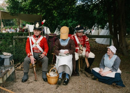 People in period clothes – some dressed as soldiers – sit on chairs outside