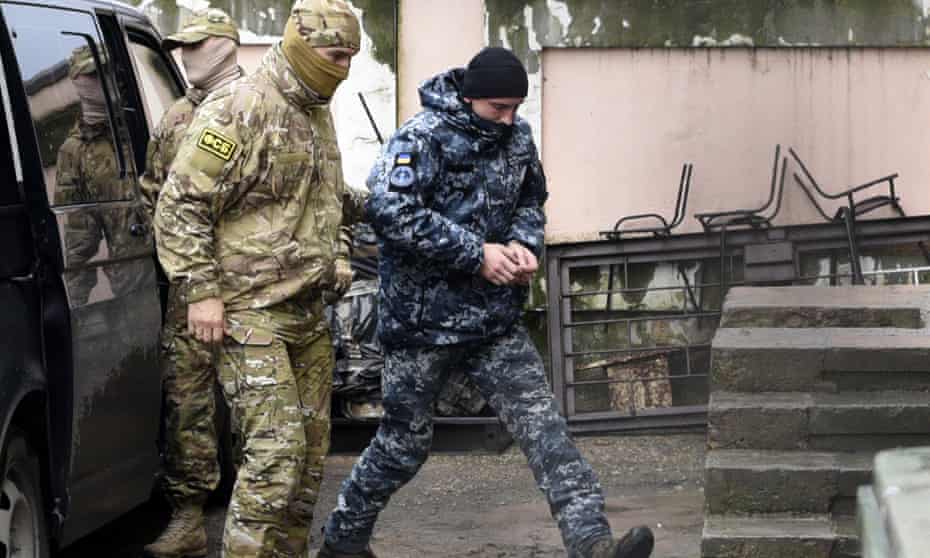 A Ukrainian sailor is escorted by a Russian FSB officer to a courtroom in Simferopol, Crimea.