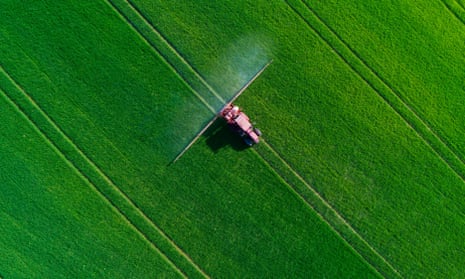 Tractor spraying field of crops