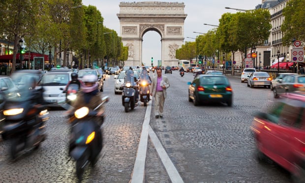 Motorbikes and cars on road in front of the Arc de Triomphe in Paris, France