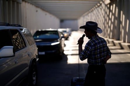 Homero Acevedo sings for tips among the line of cars waiting to cross the border to Calexico, California, on 20 July 2023, in Mexicali, Mexico.