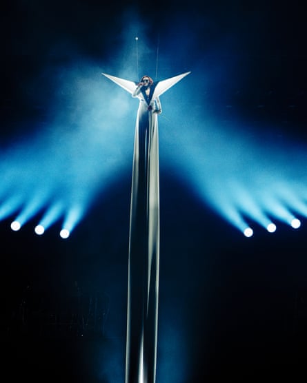 Doja Cat performing suspended in the air with a long white suit beneath her