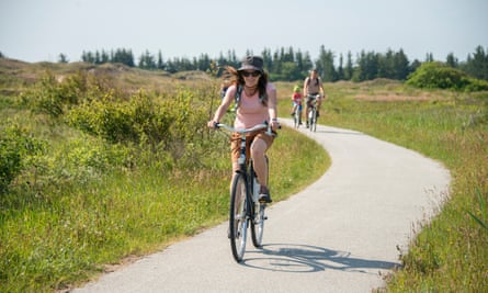 woman ride bicycle on a country road near Skagen, Denmark