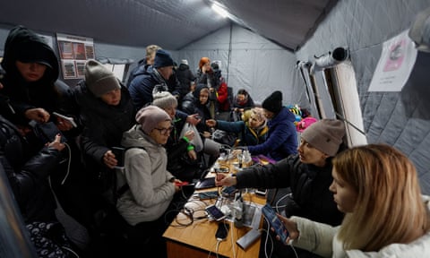 Local residents charge their devices, use the internet and warm up inside a tent in Kyiv.