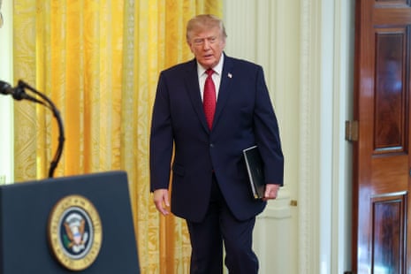 Donald Trump carries a folio while walking toward a lectern